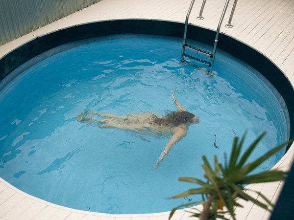 a woman submerged in pool water at Greenhouse The Bathhouse