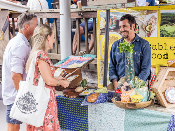 a couple talking to a stall vendor at Eumundi Markets