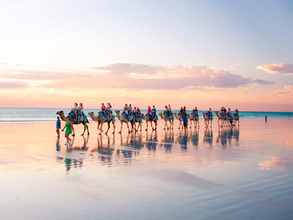 a group riding camels on Cable Beach, Broome