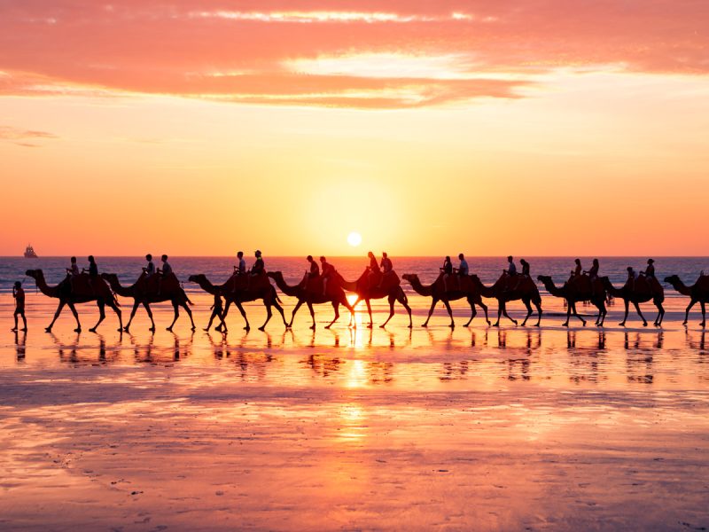 a group camel ride during sunset on Cable Beach, Broome