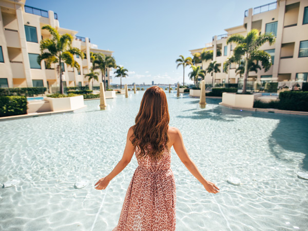 a woman standing backward facing the pool at Palazzo Versace