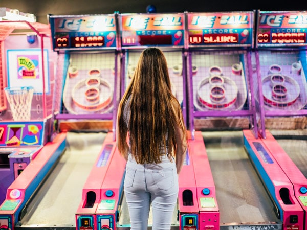 a woman facing backward at the basketball arcade in MovieWorld