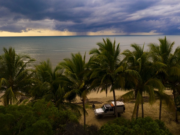 4WD sits beneath trees near the beach in the Daintree. (Image: Tourism and Events Queensland)