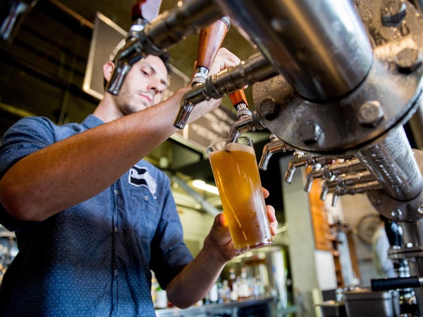 a waiter filling the glass with tap beer at BentSpoke Brewing Co