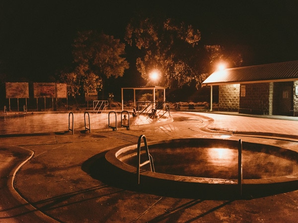 Orang menikmati berendam di Artesian Bore Baths di Lightning Ridge, buka 24 jam sehari.  (Gambar: Tujuan NSW)