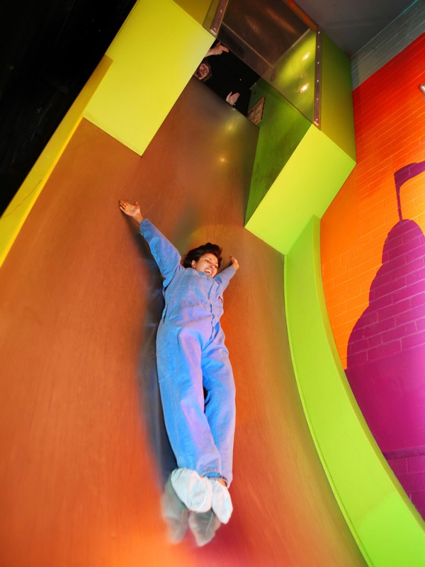 a girl sliding on a free fall attraction in Questacon