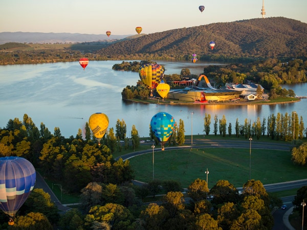 hot air balloons soaring above National Museum of Australia and Canberra