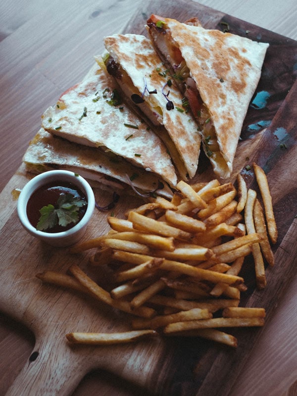 a table top view of flatbread with fries at Lonsdale Street Roasters