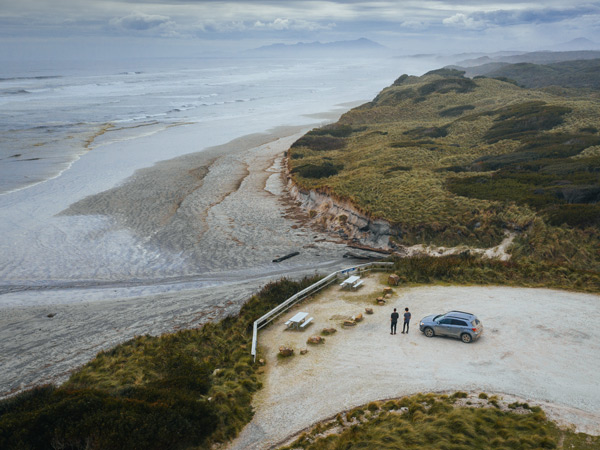 a drone shot of people and a vehicle on the side of Ocean Beach, Tas