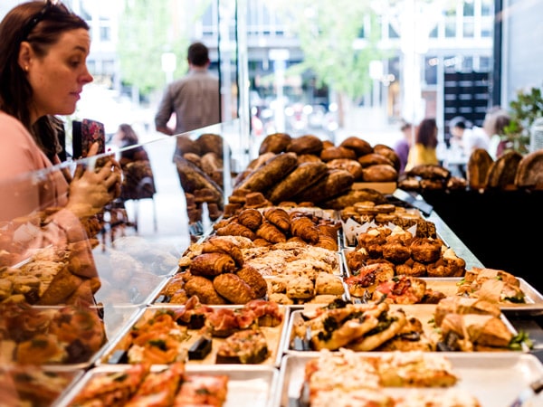 a woman thinking about what to choose from a wide selection of breads at Sonoma