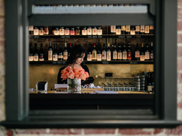 a woman holding a wine bottle at Vincent Wine, Perth