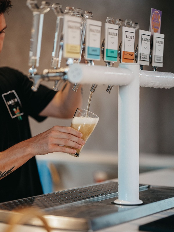 a bartender pouring tap beer into a glass at Balter Brewing Company, Gold Coast