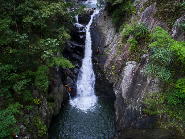 f a tour group abseiling over the waterfall on a Cairns Canyoning tour