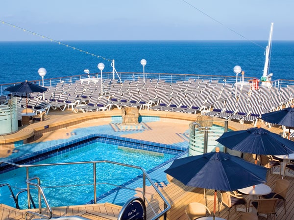 a rooftop pool with umbrellas and sun loungers at Holland America cruise ship, Australia