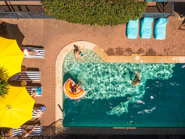 an overhead shot of people swimming in the pool at YHA Byron Bay
