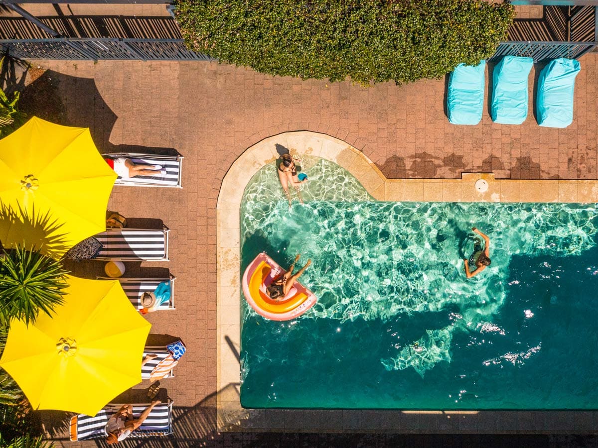 an overhead shot of people swimming in the pool at YHA Byron Bay