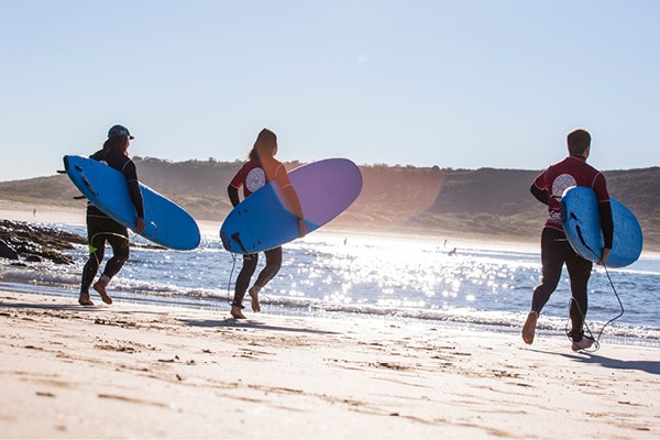 Surfers running into the waves