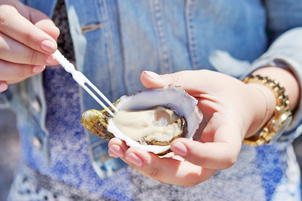Woman's hands hold an open oyster