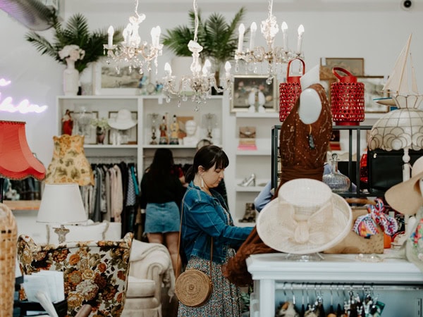 a woman browsing through vintage items on display at Designer Op Shop Emporium, Fyshwick