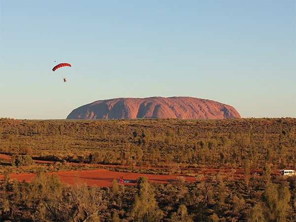 A skydiver landing at Uluru