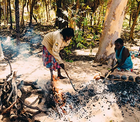 Indigenous women preparing a camp fire for cooking at A Taste of Kakadu.