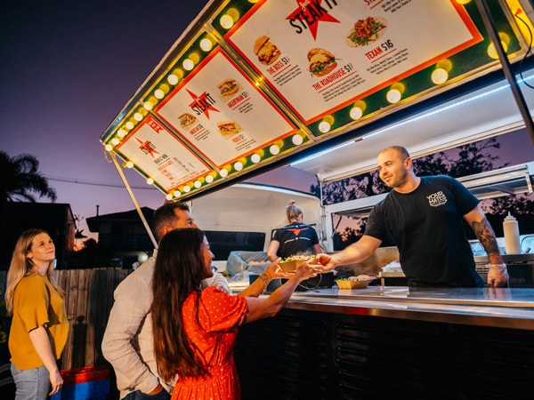 customers ordering at a burger stall in Marcoola Market