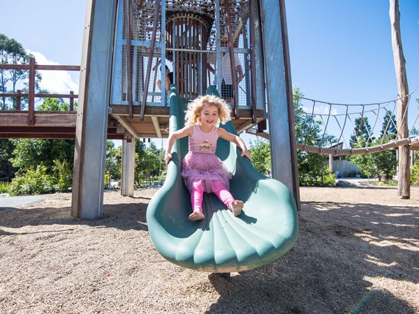 a young girl sliding down, Hinterland Adventure Playground
