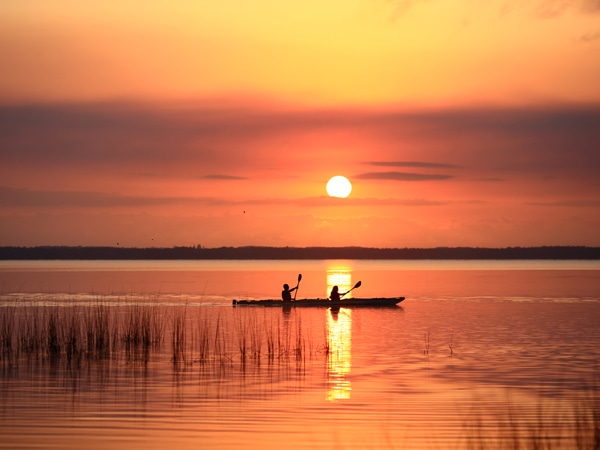 kayaking along Lake Cootharaba with sunset in the background, Kanu Kapers