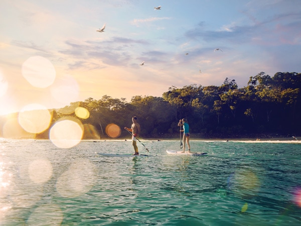 Couple stand-up paddleboarding in Tea Tree Bay in Noosa