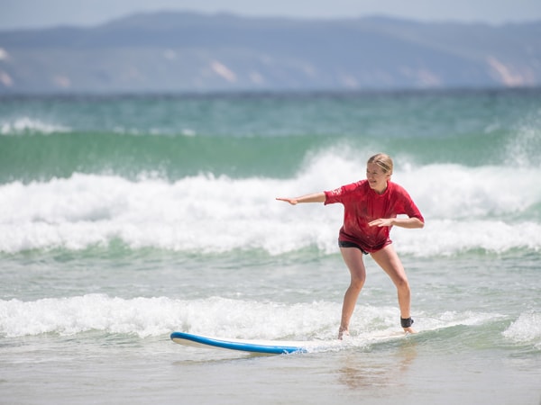 a woman surfing in Noosa Main Beach