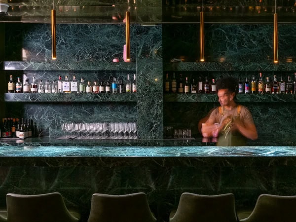 a bartender preparing drinks at the green marble bar of Bouvardia, Melbourne