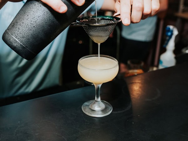 pouring a drink into a glass at Madame Brussels, Melbourne