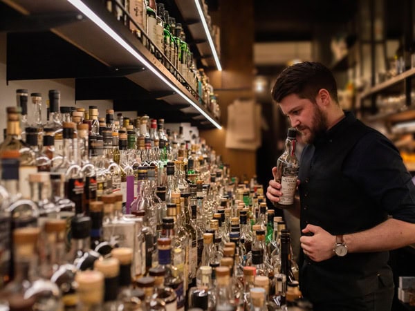 a man sniffing a bottle of whisky at Whisky & Alement, Melbourne