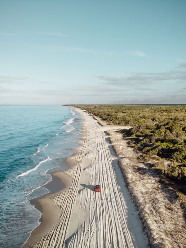 A car driving on a beach.