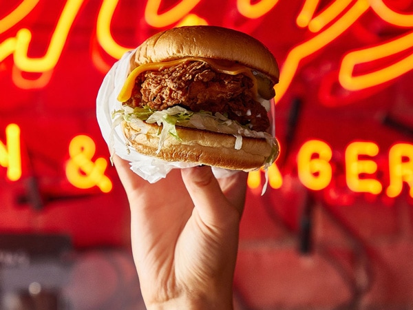 a hand holding a burger at The John Curtin Hotel, Carlton