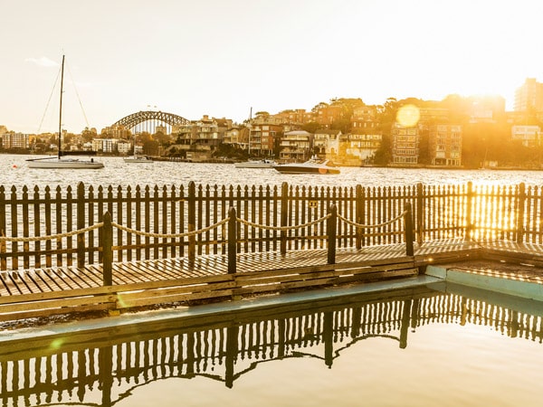 the sun rising over Sydney Harbour at Maccallum Seawater Pool, Cremorne Point