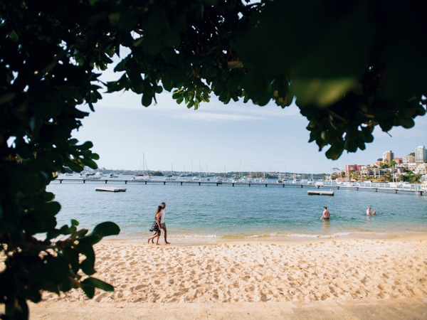 two people walking along the beach at Murray Rose Pool, Double Bay