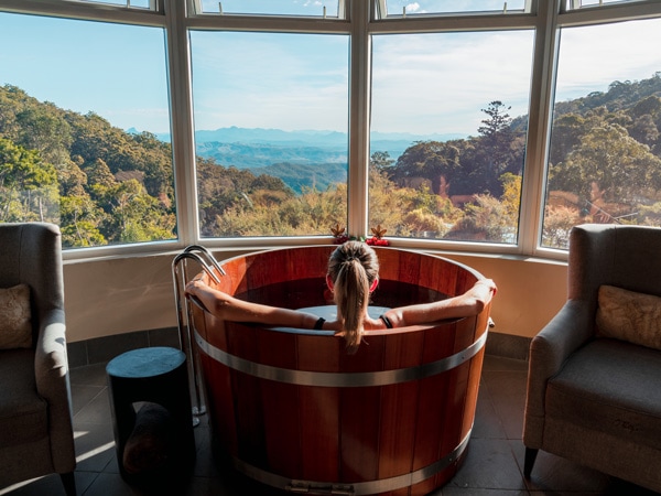 a woman soaking in a cedar tub at O'Reilly's Retreat Lost World Spa
