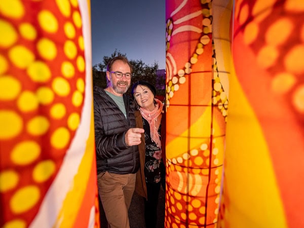 A couple explore the light installation at Parrtjima 2024