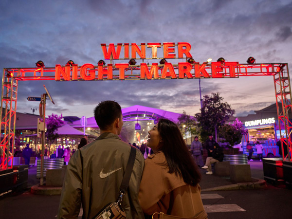 a couple arriving at the winter night market in Queen Victoria Market 