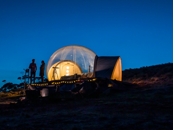 a couple relaxing in their Bubbletent Australia accommodation inthe Capertee Valley