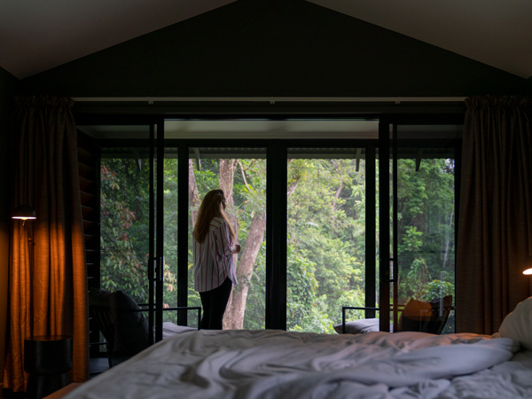 a woman staying at Daintree Ecolodge looking out the rainforest views from her room