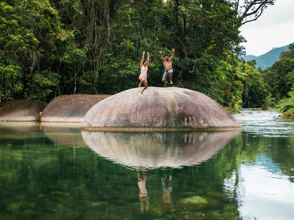 a couple jumping off straight into the water at Babinda Boulders 
