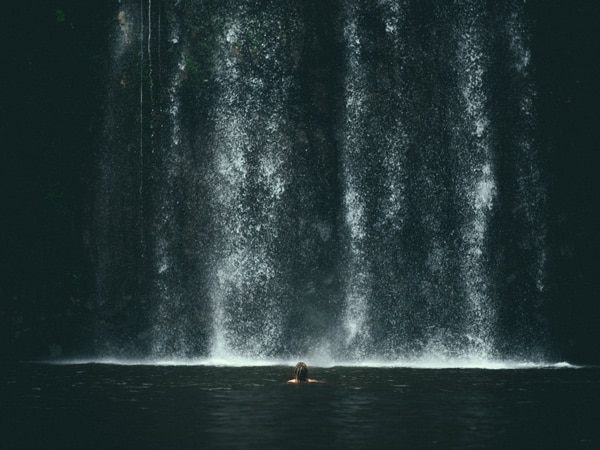 a woman dipping in Millaa Millaa Falls