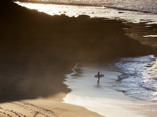 a surfer on Bells Beach at sunrise