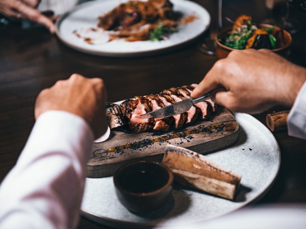 a person slicing steak at CC's Bar & Grill, Cairns
