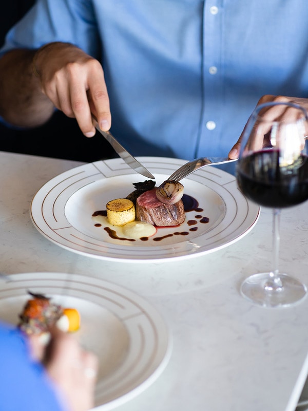 a person eating Italian food with a glass of wine