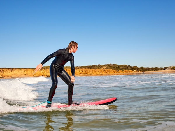 a surfer riding a surfboard at Torquay Beach