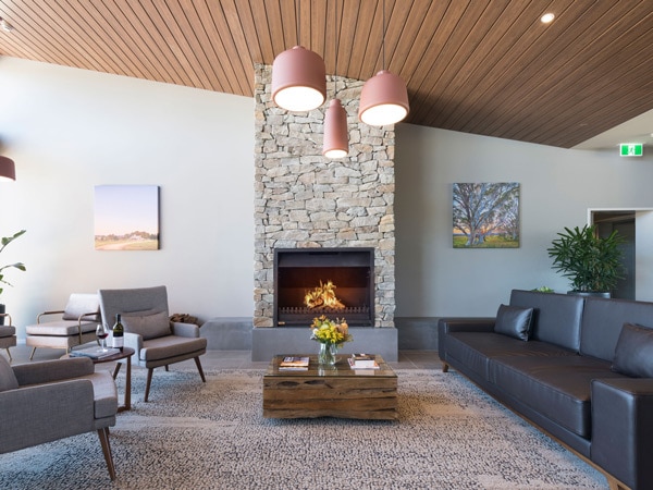a living room setup with a fireplace at Abode Hotel Canberra