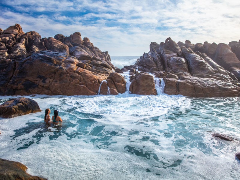 Girls swim in the natural rock pools at Injidup Beach in Yallingup.